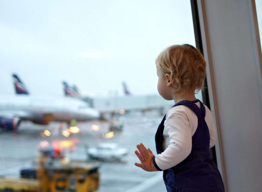 a child looking out a window at an airport. Billy Bishop