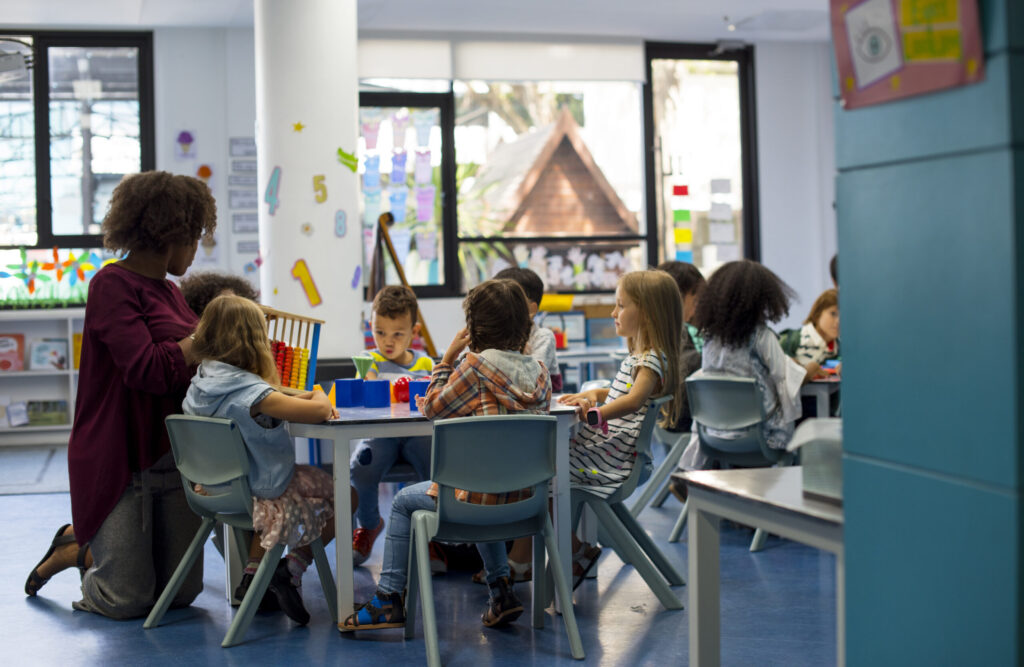 Affordable daycare setting in Toronto with wooden toy and children playing, part of Ontario’s $10-a-day CWELCC program