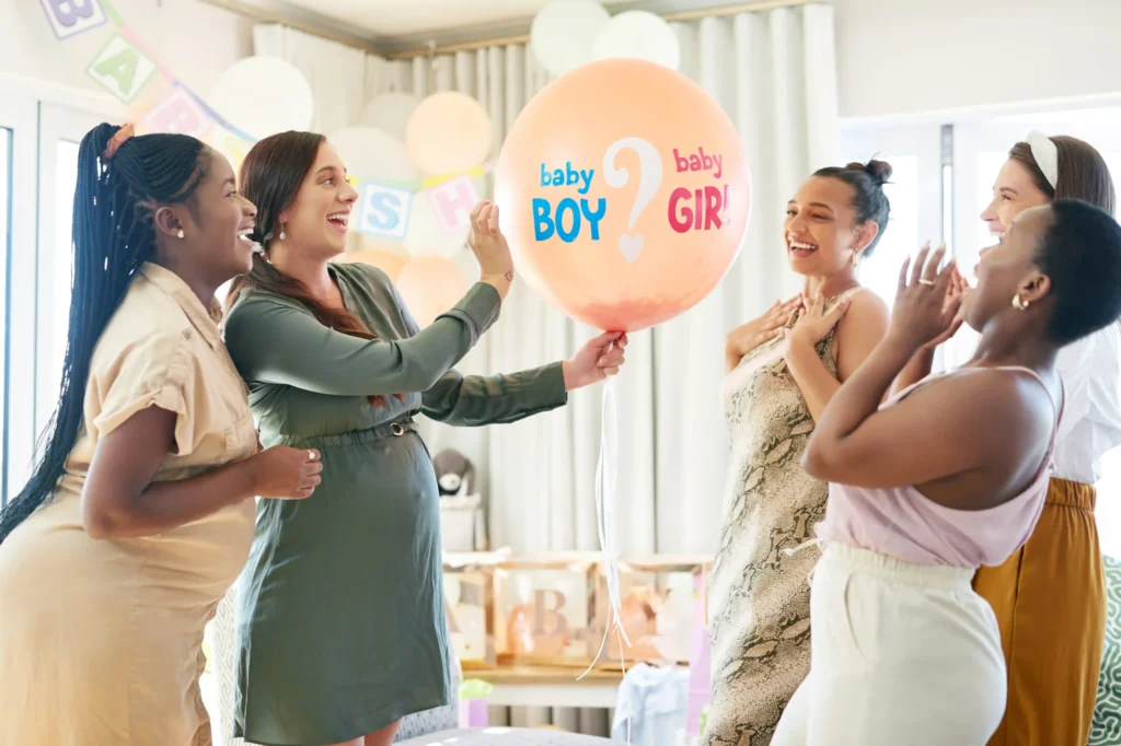 Pregnant woman at baby gender reveal party with friends in Ontario, planning 2026 EI maternity leave