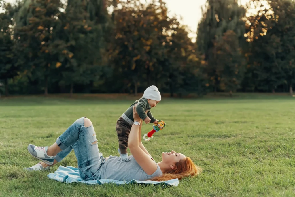 Mother on maternity leave enjoying time with baby in Toronto park, supported by EI benefits in 2026