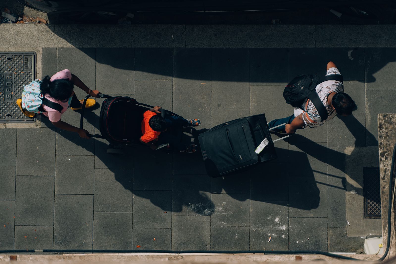 A stroller and suitcases on a city street during a trip