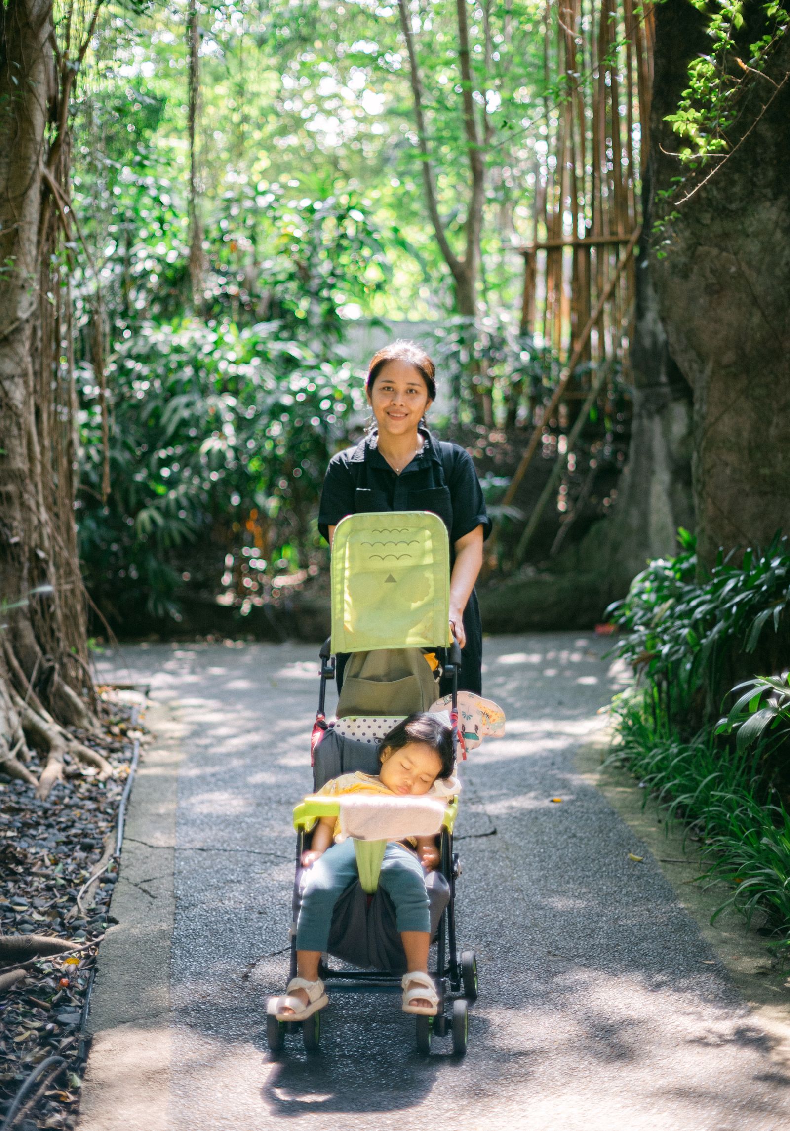 A toddler asleep in a stroller during a walk